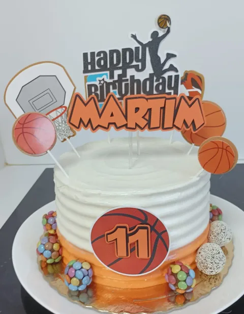 Bolo branco com bolas de basquetebol, cesto e topo de aniversário