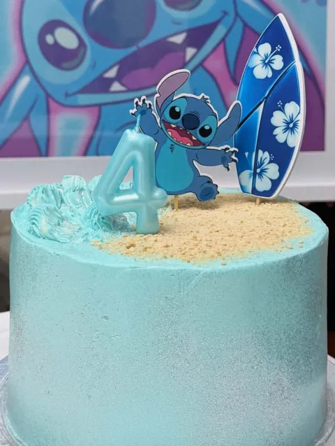 Bolo azul com o Stitch, uma prancha de surf e decoração de praia